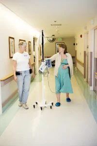 Pregnant woman walking the hospital hallways with her doula by her side.