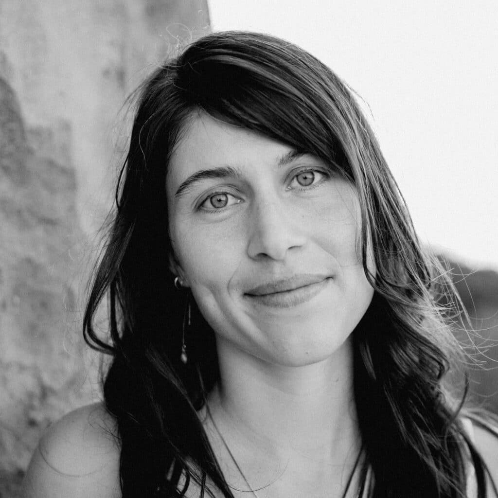 Black and white photo of a doula, a woman with dark hair looking into the camera